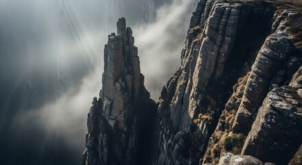 Dramatic Rock Formations Piercing Misty Clouds, Atmospheric Landscape Photography.