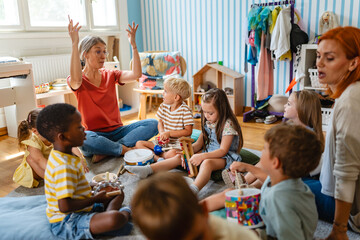 Preschool teacher leading a music lesson, engaging children in rhythm and percussion activities during group playtime