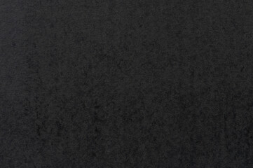 Dark texture resembling fabric or stone covering flat surface in soft lighting