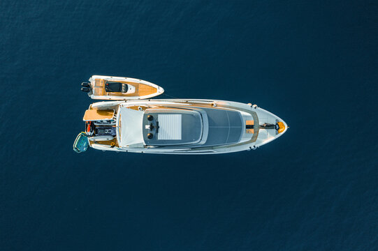 Aerial view of a gleaming white yacht cutting through the deep blue sea, a luxurious vessel leaving a subtle wake in its path, Ermioni, Argolis, Greece.