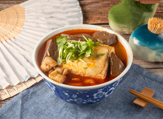Chinese Spicy Stinky Tofu with Pork Intestine and Blood Curd in Chili Broth Served in Blue Floral Bowl side view of taiwan food