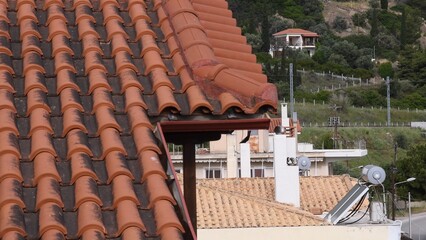 Close up view of terracotta roof tiles on Mediterranean villa overlooking beautiful landscape and greenery, capturing architectural details and rustic charm of traditional design