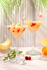 Melon alcoholic cocktail with mint. Martini and royal sangria with melon slices, ice, mint and currants. Summer party concept, advertising for a bar or cafe, detox diet