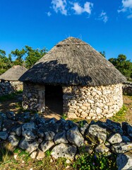 Ancient stone hut under thatched roof