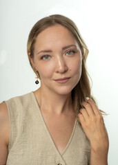 Naklejka premium Young woman in beige vest confidently posing on white background 