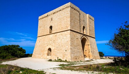 Fototapeta premium Ancient stone tower against blue sky