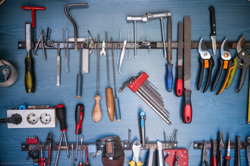 various tools in a shed on a blue wooden board