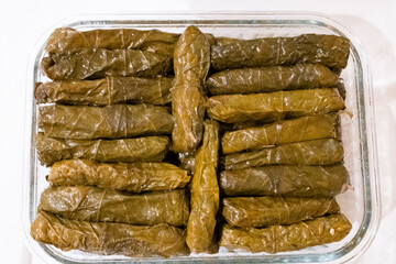 Deliciously rolled grape leaves stuffed with rice and spices, beautifully arranged in a glass dish, ready to serve.