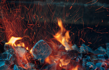 the fire burns in the fireplace with coals.