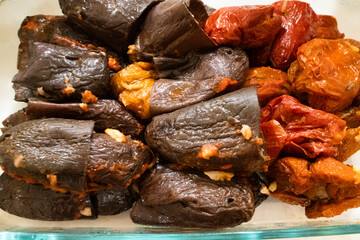 A close-up view of stuffed eggplant and pepper, featuring dark and red fillings showcasing a vibrant mix of textures and colors