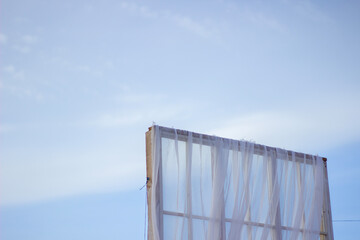 Clear Fabric Billowing in the Gentle Breeze Against a Bright Blue Sky During a Sunny Afternoon