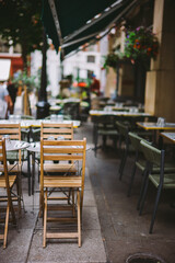 Charming Cozy Outdoor Cafe with Empty Tables and Greenery on a Bustling Urban Sidewalk