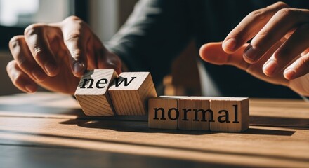 Hands arranging wooden blocks with the words "new" and "normal