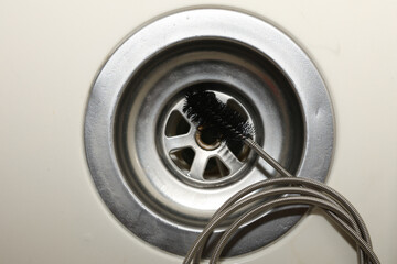 Obraz premium Cleaning of drain with plumber's snake, closeup