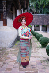 Fototapeta premium Pretty Asian Thai woman wearing traditional Thai dress costumes according to Thai culture at the ancient temple in famous tourist attraction in Thailand.