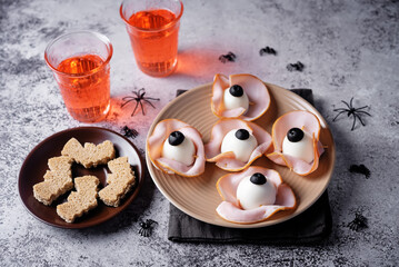 Halloween appetizer with eggs, black olives and ham in the form of eyes