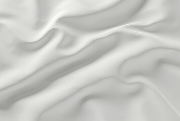 Fototapeta premium Abstract close-up of a white fabric with soft folds and subtle shadows creating a smooth, flowing texture.