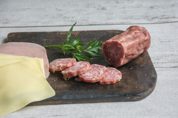 ham, cheese and salami on on a wooden board. Top view