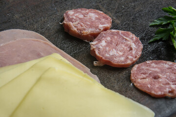 ham, cheese and salami on on a wooden board. Top view