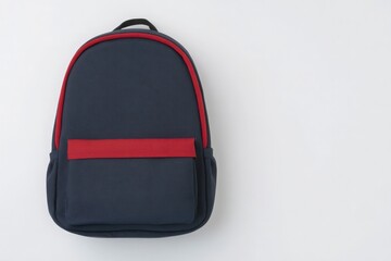 Fototapeta premium A navy blue backpack with a bold red front pocket is centered on a plain white surface. The design features a simple and modern aesthetic, suitable for school or travel use.