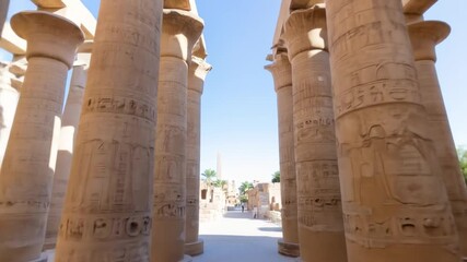 Ancient Temple: A majestic view of colossal columns, meticulously carved with hieroglyphs, forming an imposing and historically rich architectural structure against the bright sky.