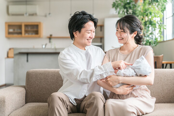 赤ちゃんと出産後の育児休暇を過ごす若い夫婦・親子・家族・ファミリー
