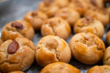 Deliciously baked almond cookies with a golden hue, showcasing a nut on top, perfect for dessert or snacking