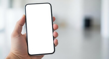A hand holds a smartphone with a blank white screen, presented against a blurred background.