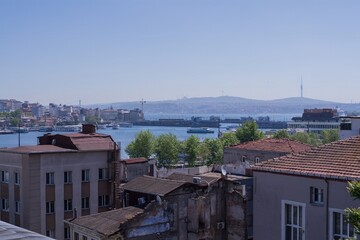 Istanbul cityscape with Suleymaniye Mosque domes, historic architecture, Bosphorus Strait with ships, Galata district and bridge on horizon on a bright summer day.