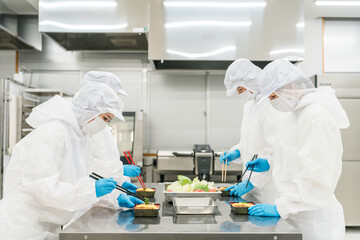 お弁当の盛り付けをする男女（食品工場,食品加工,食品衛生）  © buritora