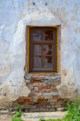 A new plastic window in an old brick wall with crumbling plaster