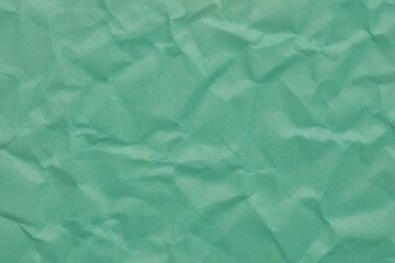 Obraz premium Crumpled Turquoise Paper Creating a Textured Background for Creative Projects and Designs in an Artistic Setting