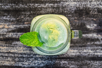 Top view of cold or ice matcha blind on the wooden table. Close up, High angle, above. Isolated.