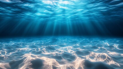 Underwater scene: clear azure seawater and sandy seabed, sunlight penetrating surface creating visible light rays, illuminating rippled sand patterns, water surface showing waves and light reflections