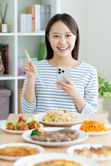 食べ物をスマホで検索する若い女性