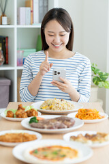 食べ物をスマホで検索する若い女性