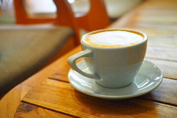 Cup of coffee on wooden table in cozy cafe setting