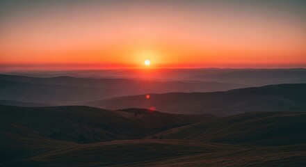 Obraz premium Sunset Over Rolling Hills with Vibrant Orange Sky, Creating a Peaceful and Serene Landscape, Ideal for Travel and Nature Photography