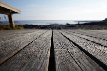 Close-up weathered wood decking overlooking ocean