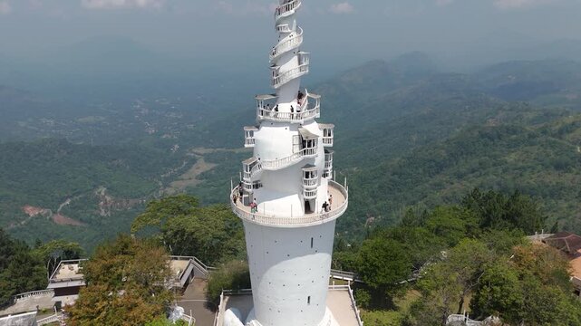 Aerial 4K drone footage of Ambuluwawa Tower, Sri Lanka. Stunning views of the iconic spiral tower, lush hills, and panoramic landscapes perfect for travel, cultural, and architectural projects.
