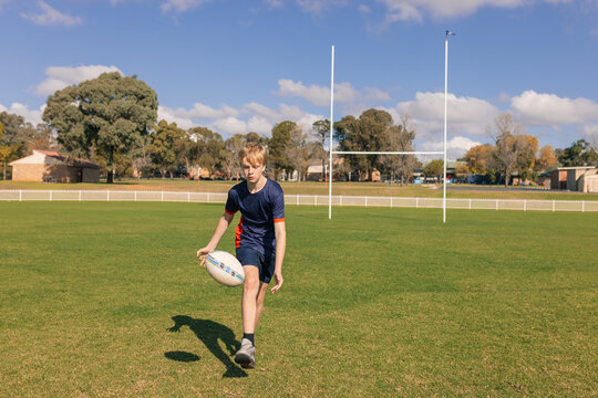 Junior rugby union player chasing ball on field