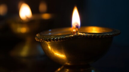 Golden diya glowing in darkness, symbolizing tradition and festive spirit in Indian culture.
