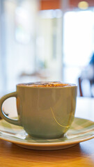 Hot cappuccino coffee topped with frothy milk and sprinkled cocoa powder