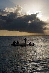 Pier de madeira no Caribe em Curaçao ao pôr do sol, com raios de luz refletindo no mar calmo e cenário tropical sereno, ideal para transmitir paz e beleza natural