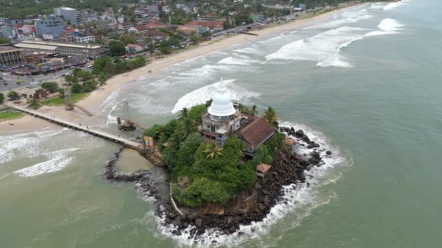 Aerial 4K drone footage of Matara Temple, Sri Lanka. Stunning coastal Buddhist temple with ocean views, lush greenery, and cultural heritage&mdash;perfect for travel, tourism, and spiritual projects.