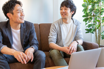 パソコンの前で話をしている2人の日本人男性