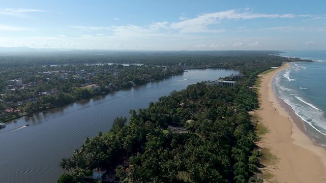 Aerial 4K drone footage of Bentota Beach, Sri Lanka. Beautiful tropical coastline, golden sands, palm trees, and turquoise waters ideal for travel, tourism, beach, and tropical vacation projects.