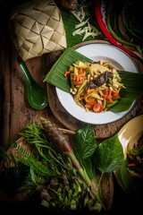 Som Tam , a popular and favourite Thai food dish made of young sliced papaya, chili, tomatoes, palm sugar and dried shrimp , top view.