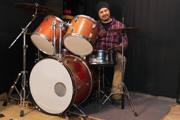 Fototapeta premium Man playing acoustic drums in a studio