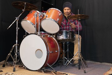 Man practicing with his drum kit in the studio